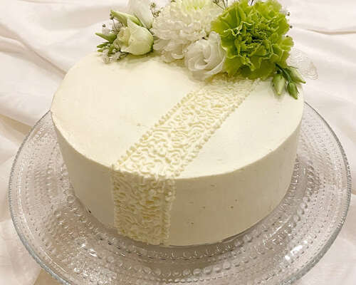 Valkoinen kakku oikeilla kukilla