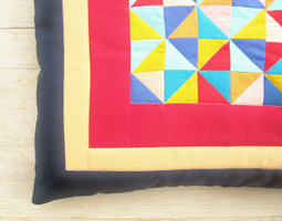 Värikästä kolmiomosaiikkia tyynyssä